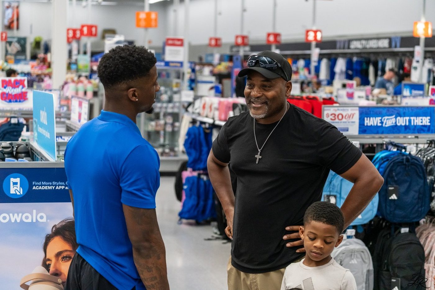 Anthony Miller II greeting families with children inside Academy Sports