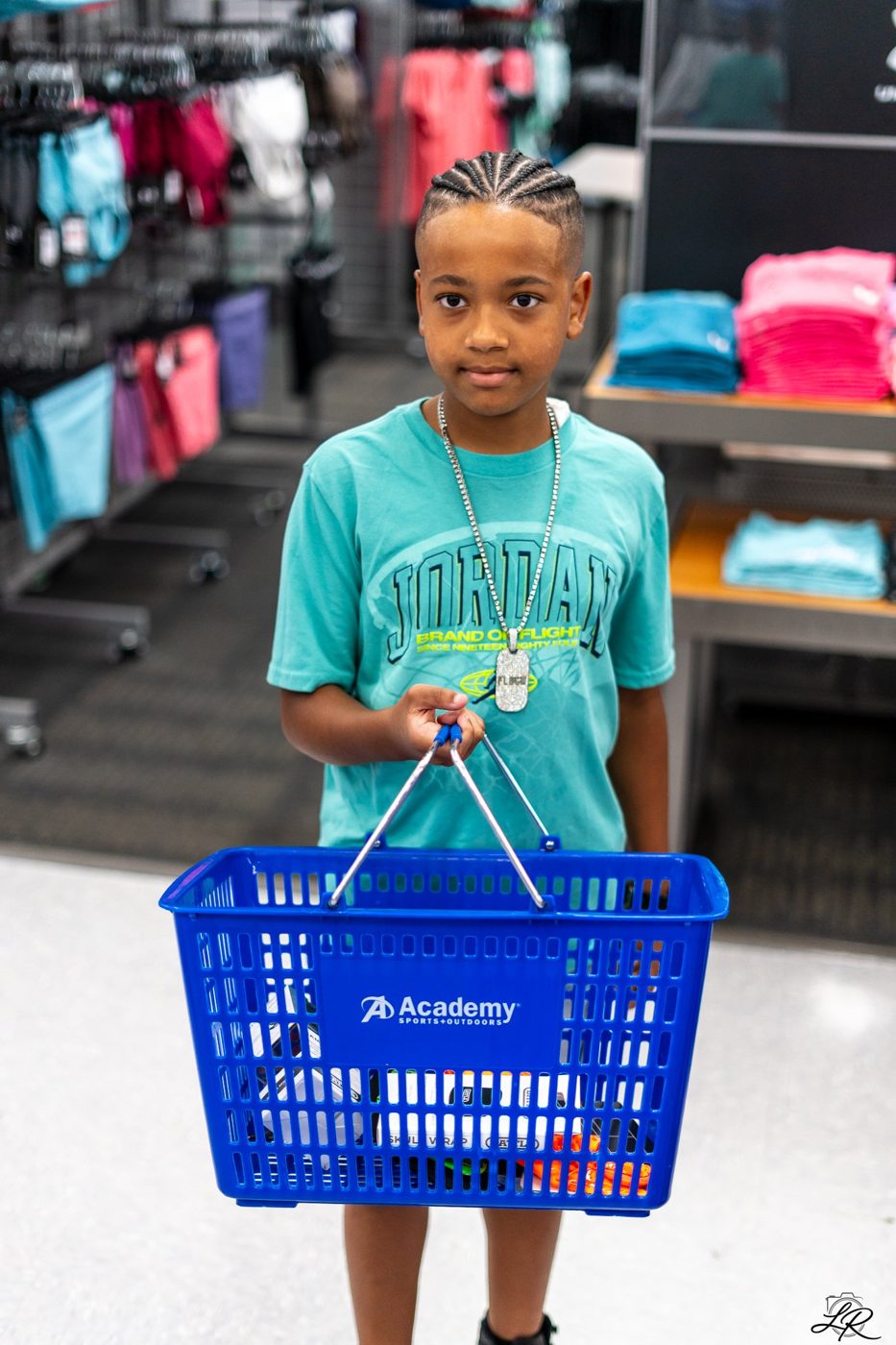 A young shopper holding an Academy Sports basket during the giveaway