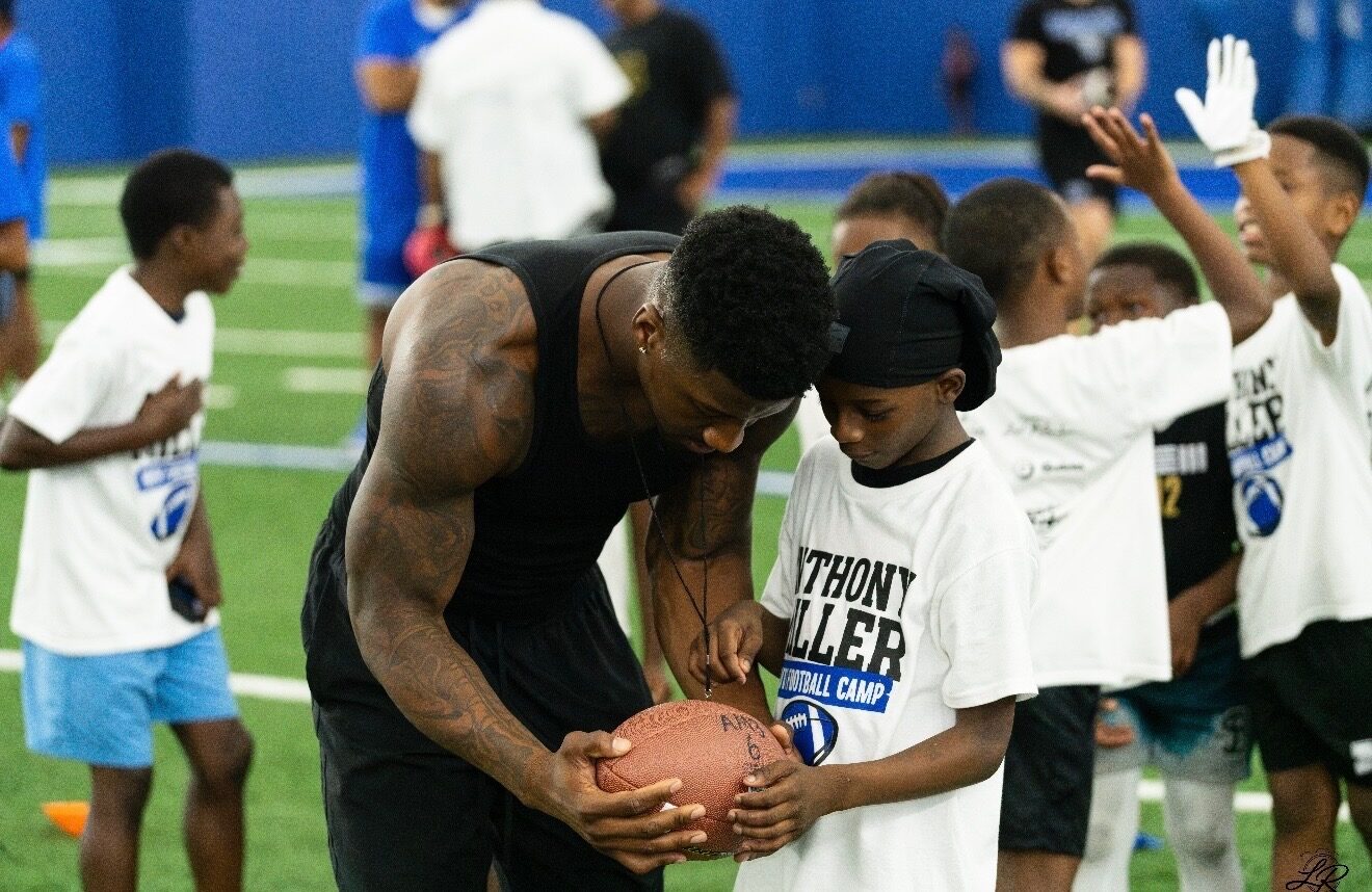 Anthony Miller II running a drill on the field at the youth football camp