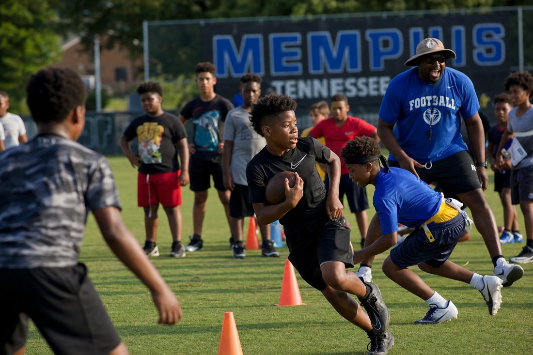 Youth running drills at an AM3 football camp