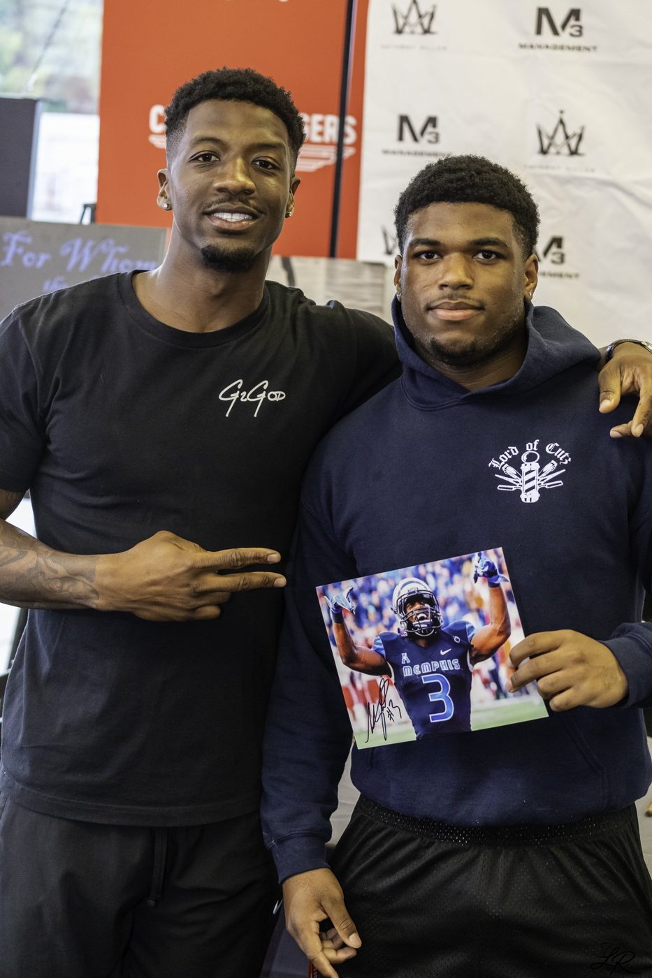 Anthony Miller posing with a young fan holding an autographed photo