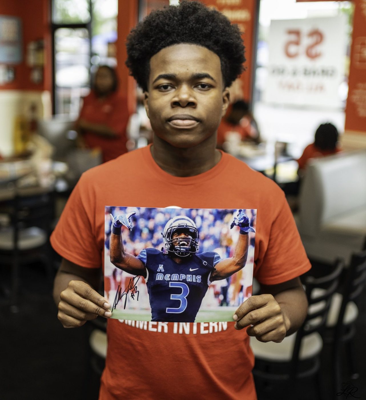 A young fan proudly holding his autographed Anthony Miller photo